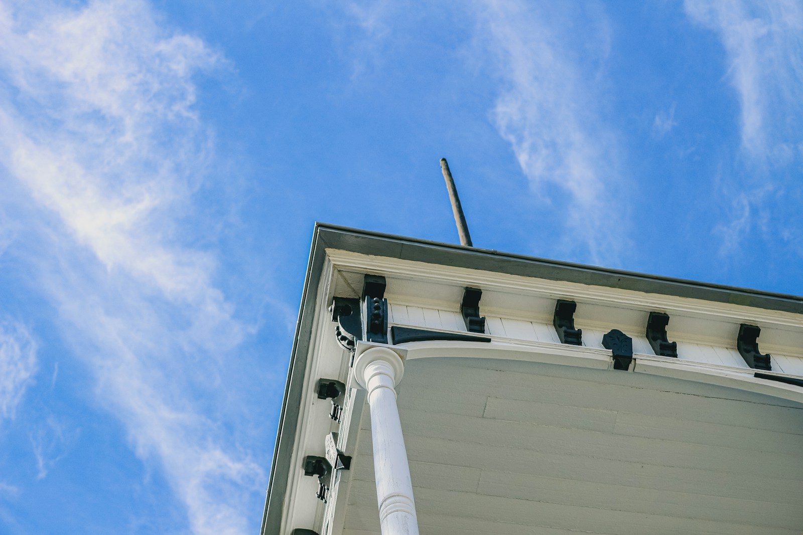 Gutter Replacement in Raleigh: White building eaves against a blue sky