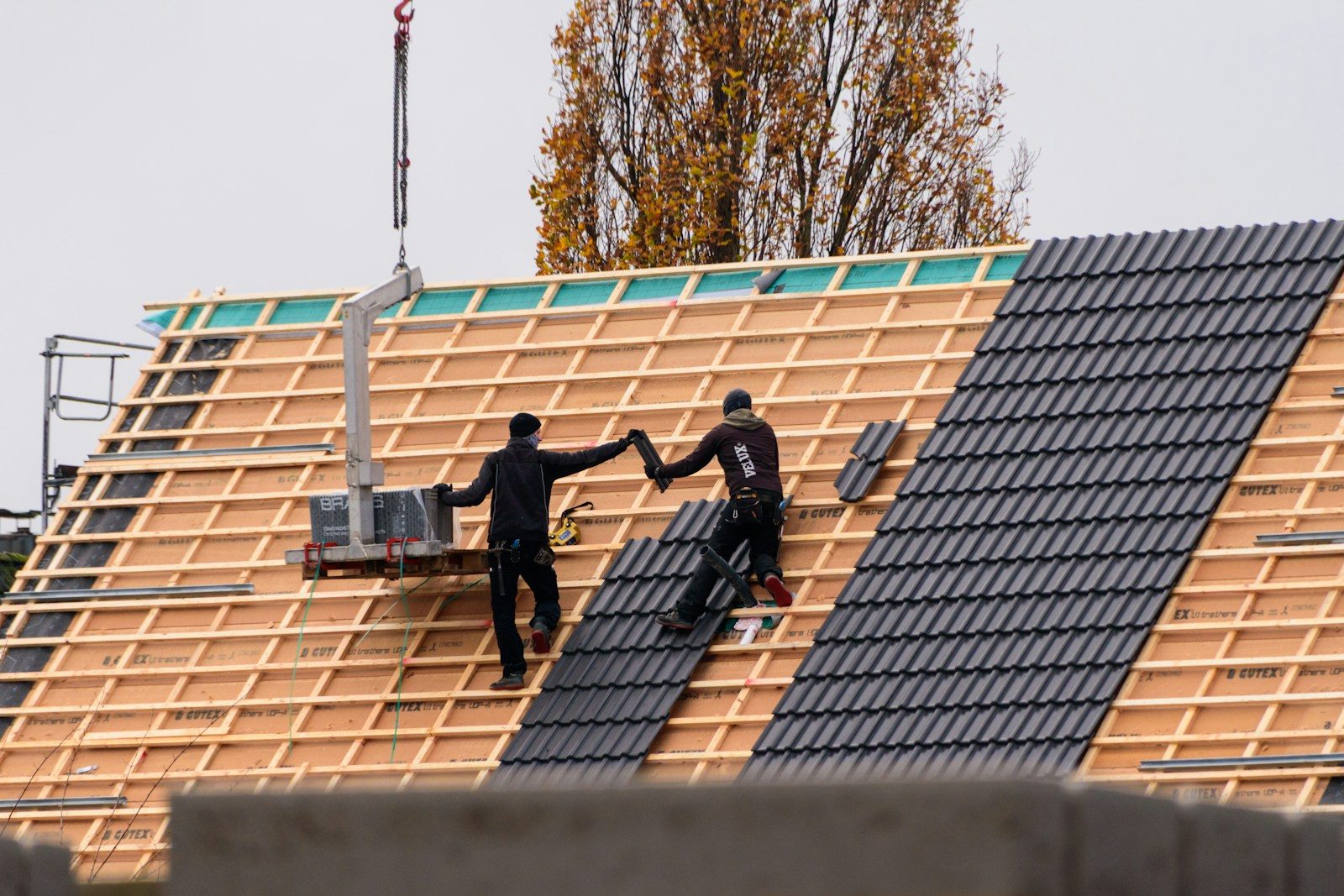 Best Roof Repair Services in Winston-Salem: Workers installing roof tiles on a new building