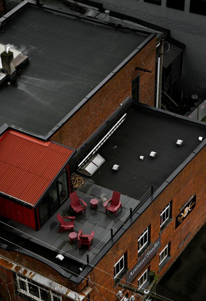 Commercial Roofing Maintenance in Winston-Salem: Rooftop patio with red chairs and tables